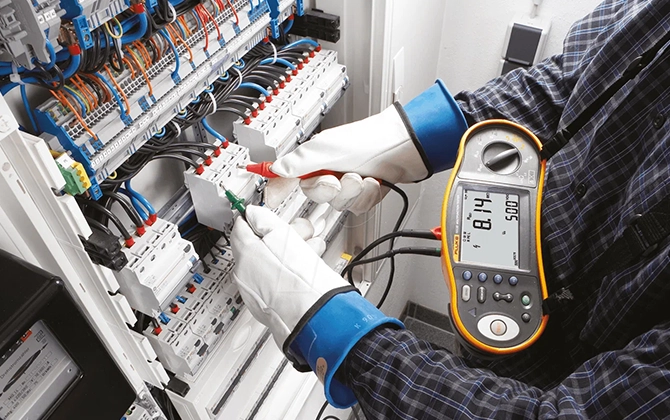 Electrician testing generator panel for diesel genset load performance during repair and maintenance